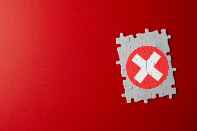 赤い背景の前にあるバツマーク